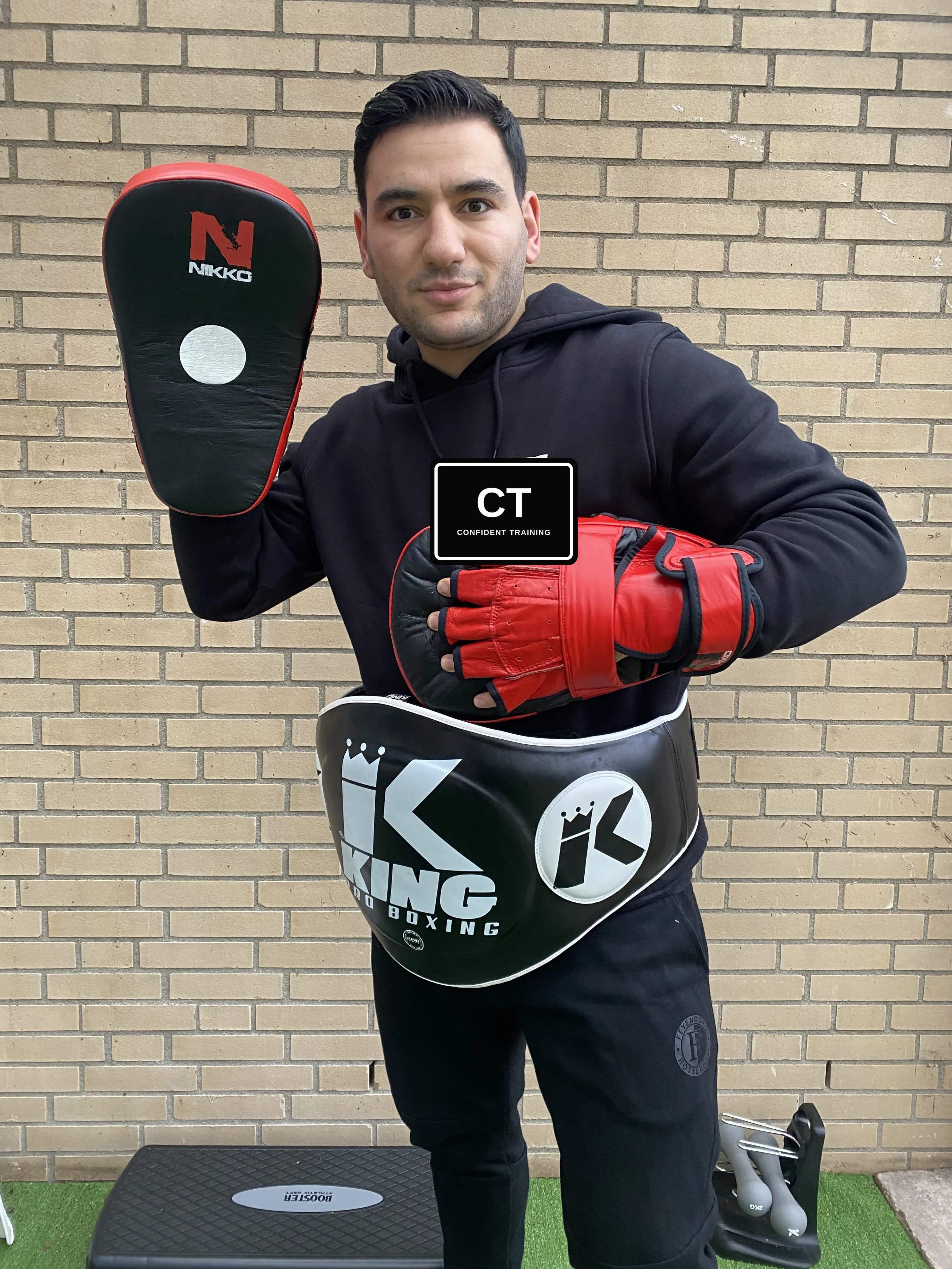 Trainer van Confident Training met focuspads tijdens bokstraining